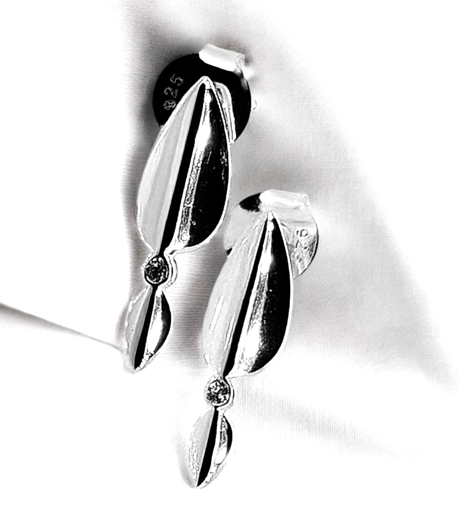 Sterling silver stud earrings feature two folded curved strips of silver that meet at the center with a sparkling white zirconia gem