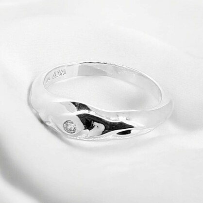This mottled sterling silver band ring exudes a unique charm with its texture & single zirconia