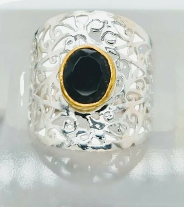 A polished black onyx known for its grounding and protective qualities anchors the design in ths large silver web ring